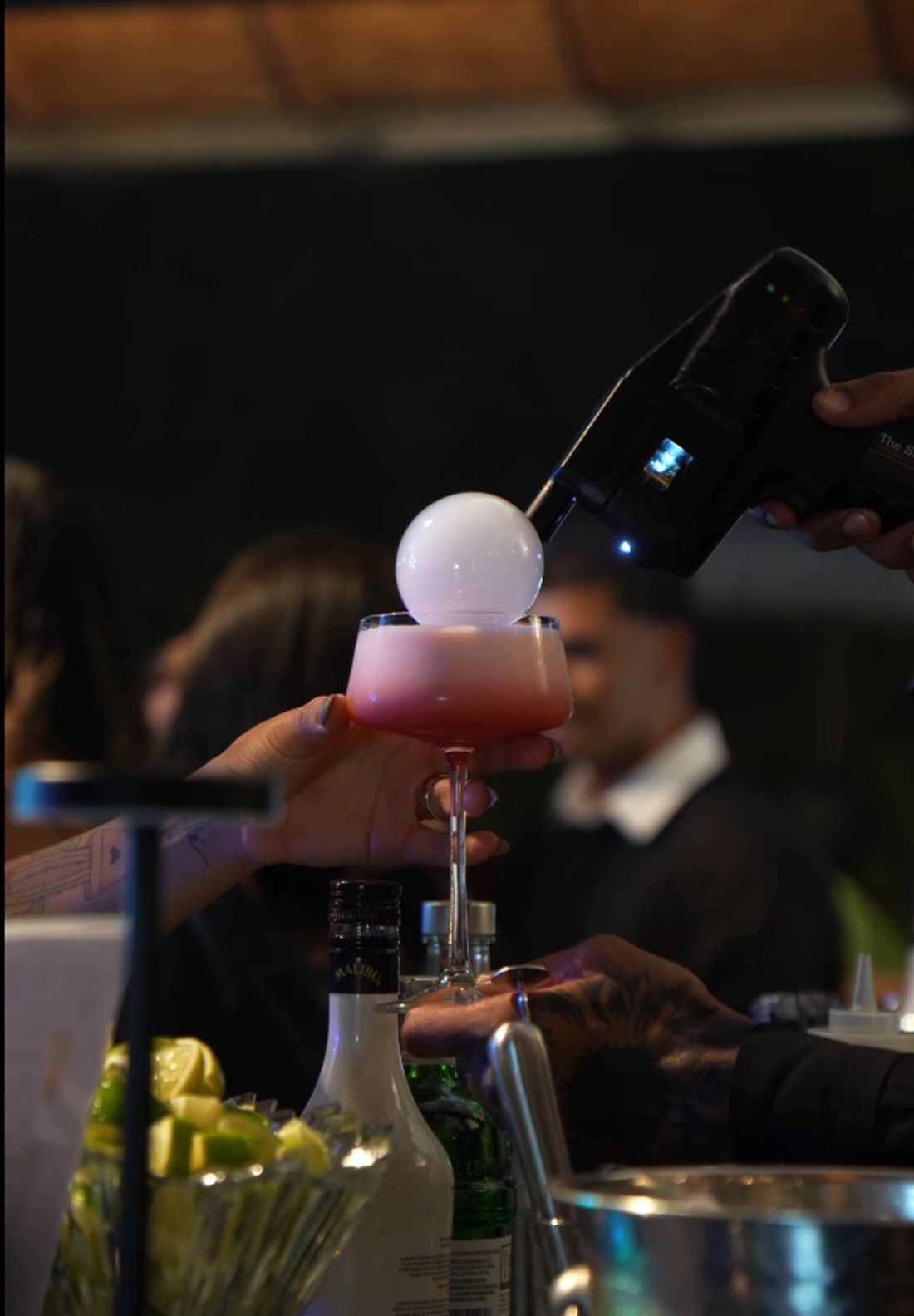 Bartender finalizando um drink com bolha de fumaça em um evento