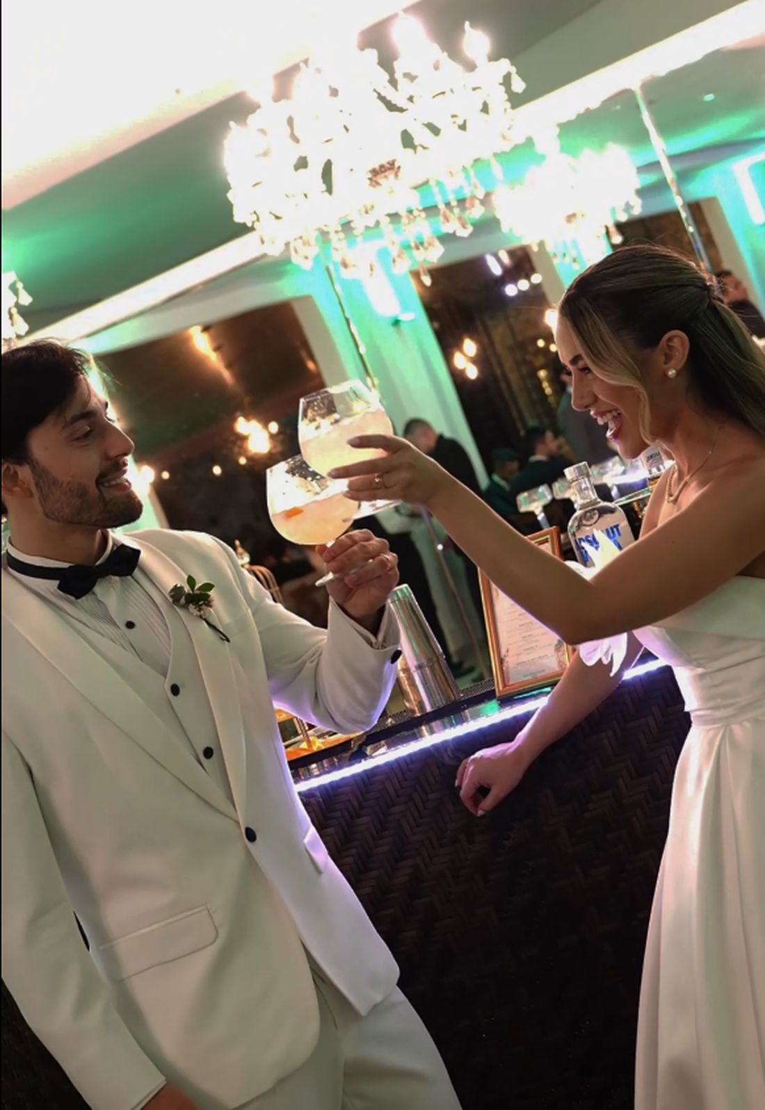 Noivos brindando com drinks autorais no bar do casamento